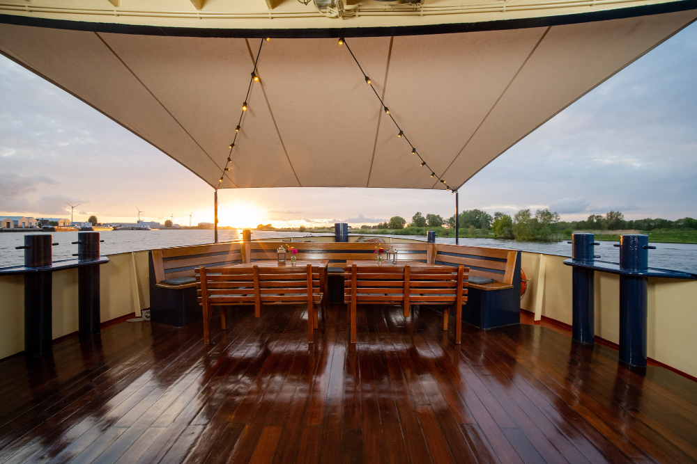 toldo para área externa com mesa e cadeiras ao lado de um lago